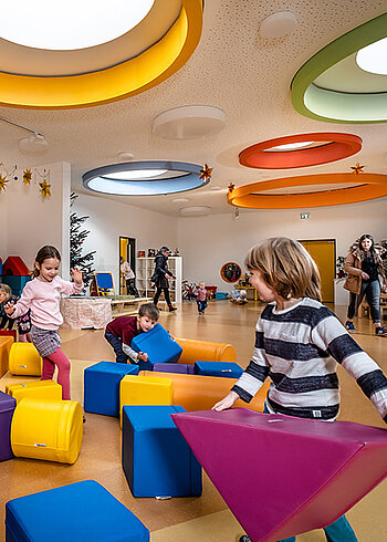 Kinder spielen in einem bunt dekorierten Raum.