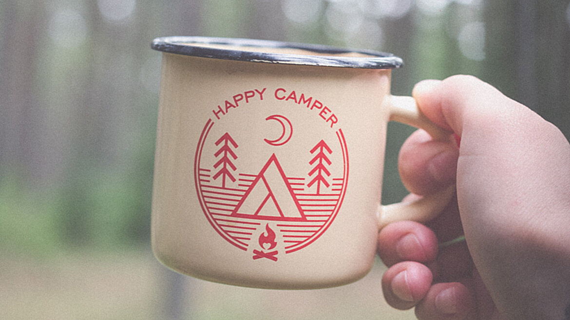 Hand hält Tasse im Wald 