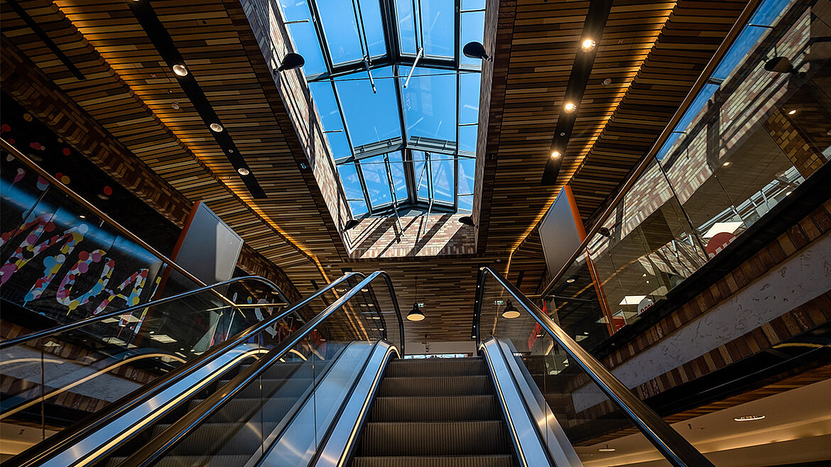 Einkaufszentrum mit Glasdach über Rolltreppen