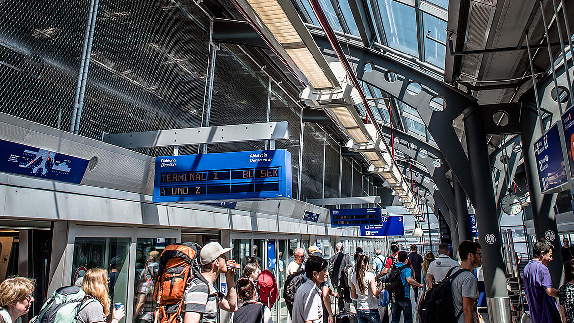 Menschen am Flughafenbahnhof Frankfurt beim Umsteigen Schalldämmung durch das Glasdach am Flughafenbahnhof Frankfurt