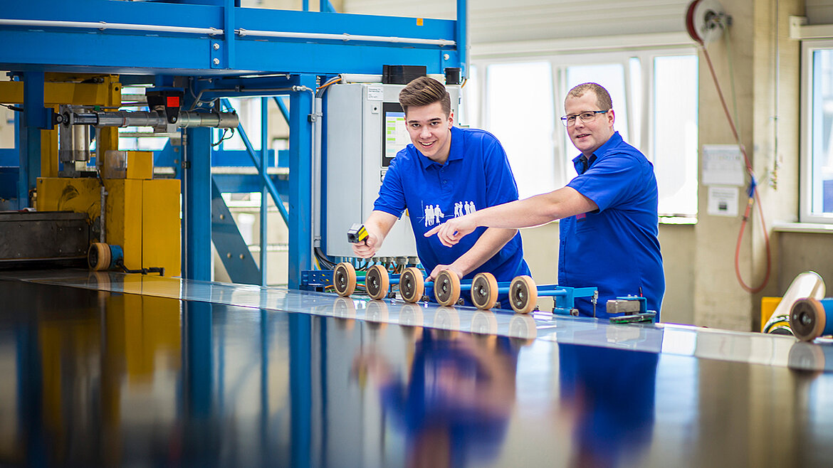 Ausbilder und Auszubildender zum Verfahrensmechaniker Ausbilder erklärt Azubi Produktionsanlage | karriereblog by LAMILUX