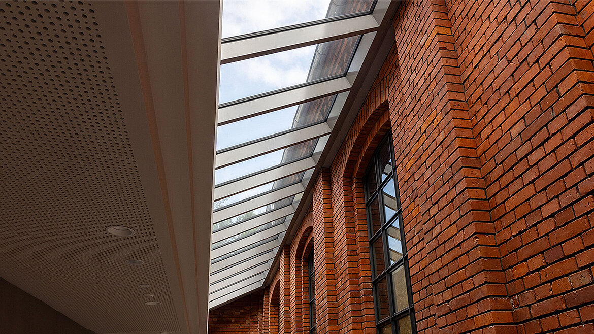 LAMILUX Glasdach Fire Resistance mit brandschutzgeprüfter Verglasung entlang historischer Backsteinfassade