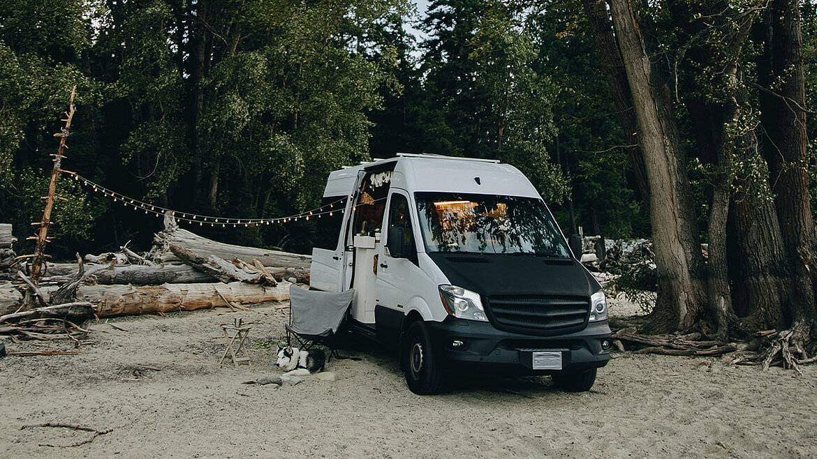 Camper Van am Strand mit Lichterketten