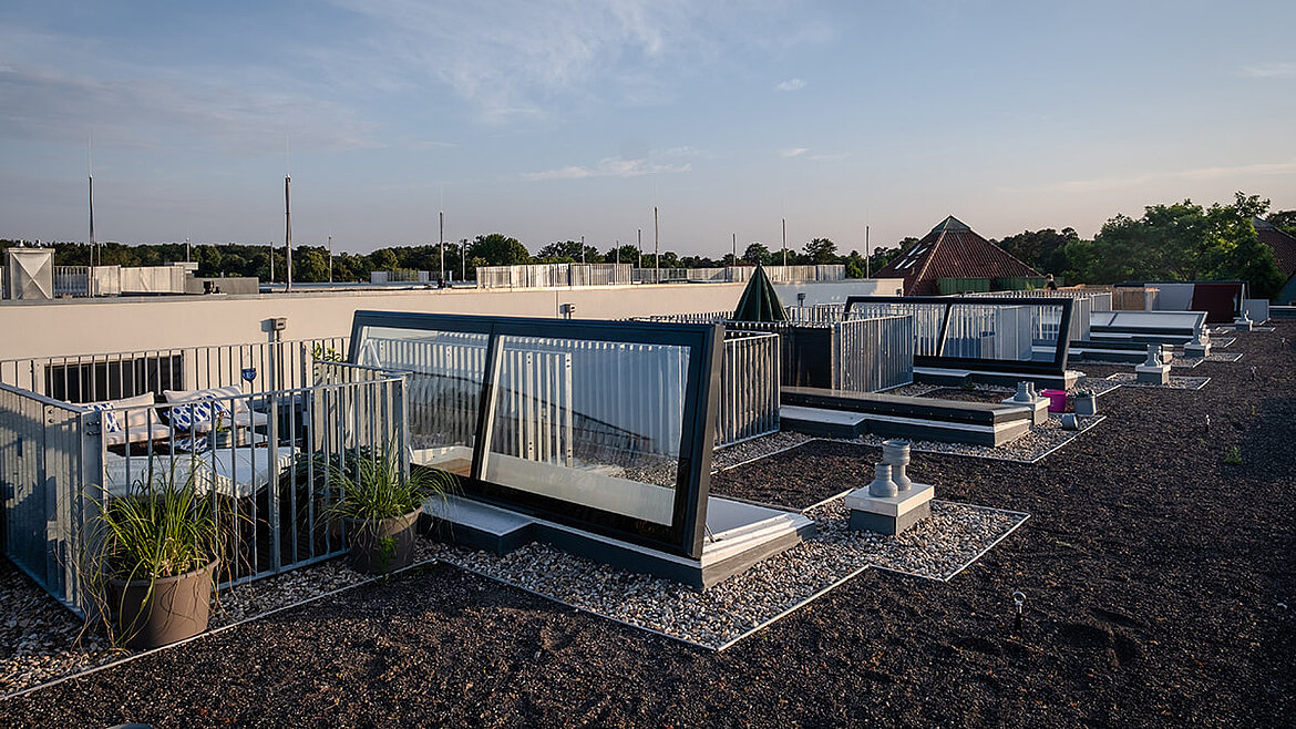 Moderne Dachterrassen mit Glasaufgängen und Begrünung in urbaner Umgebung.