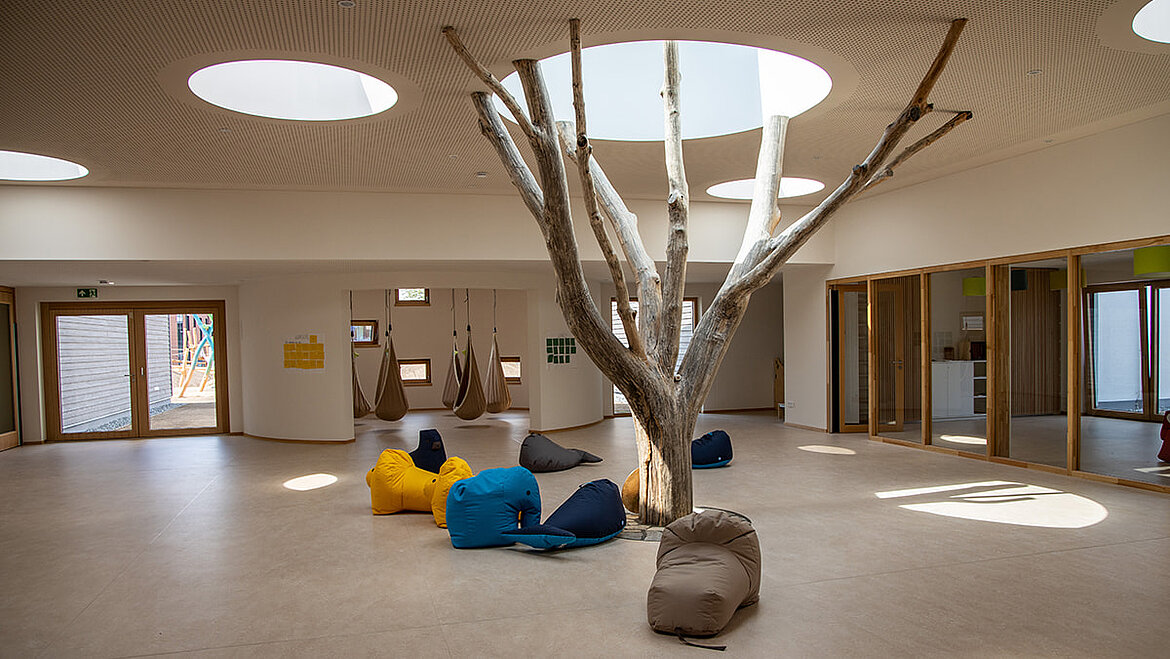 Baum im Innenbereich der LamiKita Innenbereich der LamiKita mit Baum und Glasdach | insights by LAMILUX