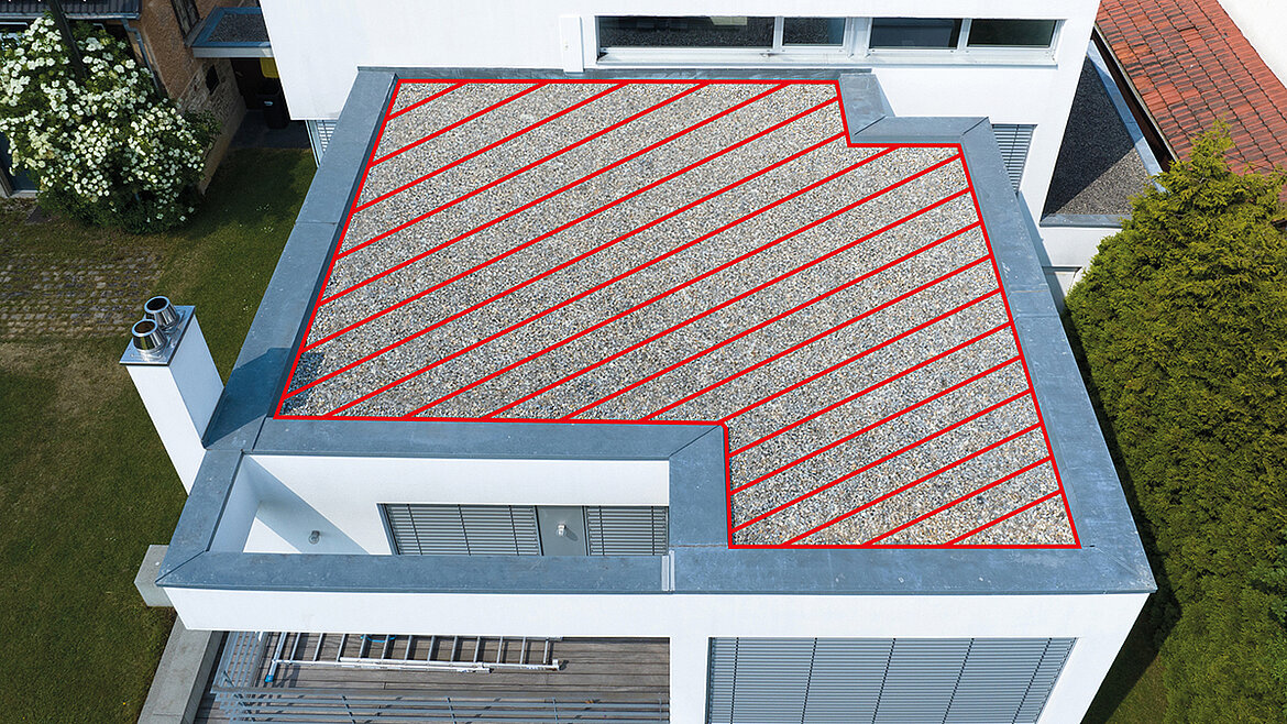 Flachdach eines modernen Hauses mit Kiesbelag, rot markierter Fläche und umlaufender Attika.